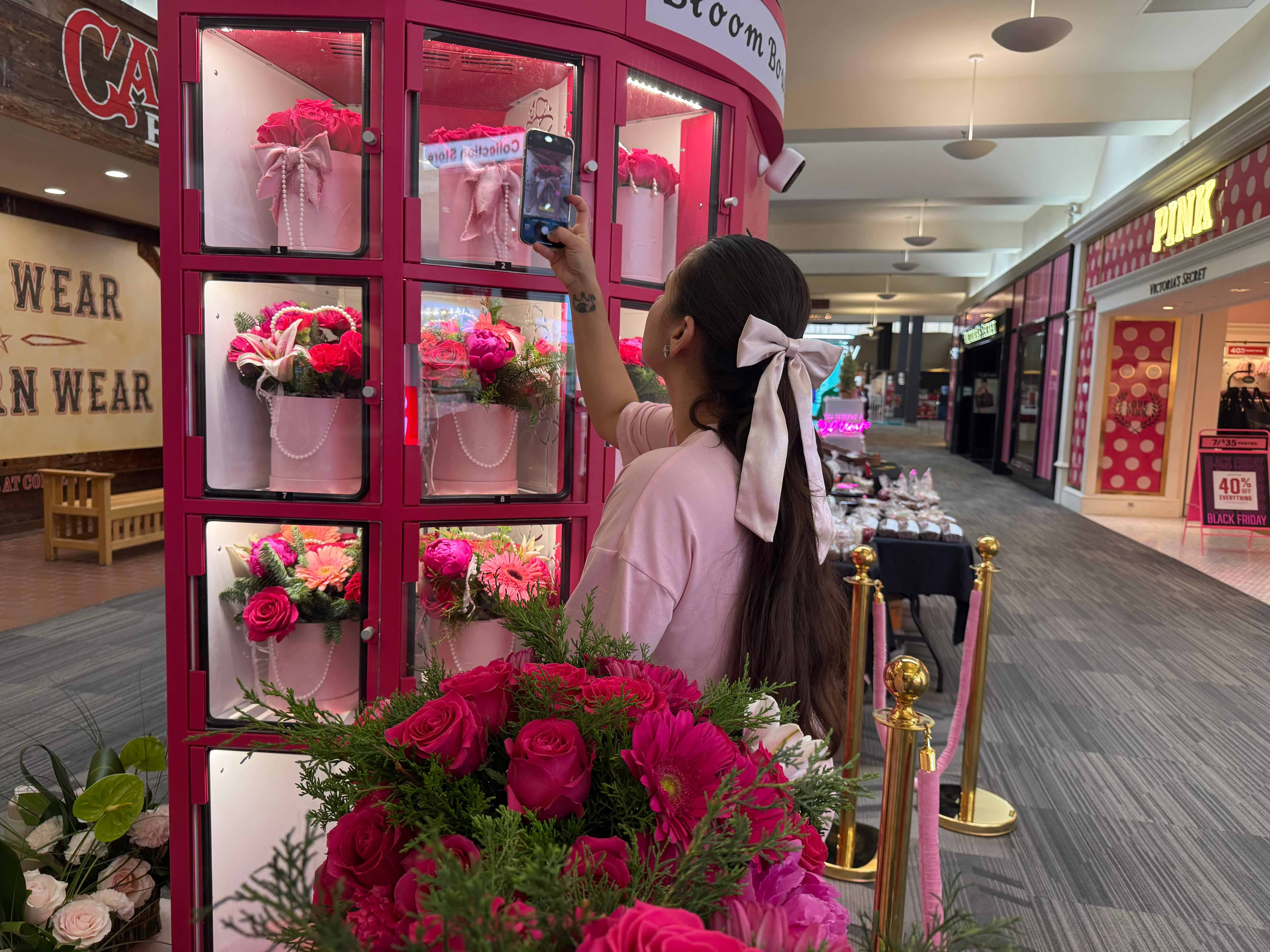 a customer is taking a photo of pink flower vending machine