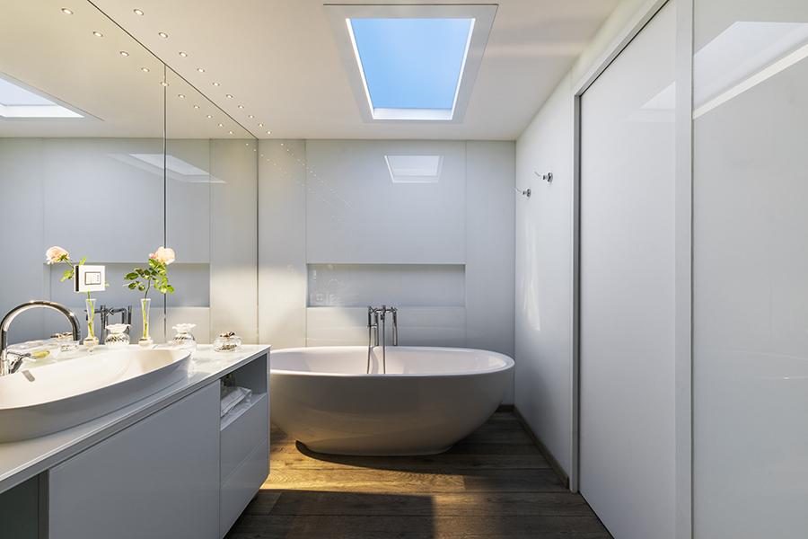 Ultra-thin skylight installed in dark bathroom, creating blue sky and sunlight ambiance