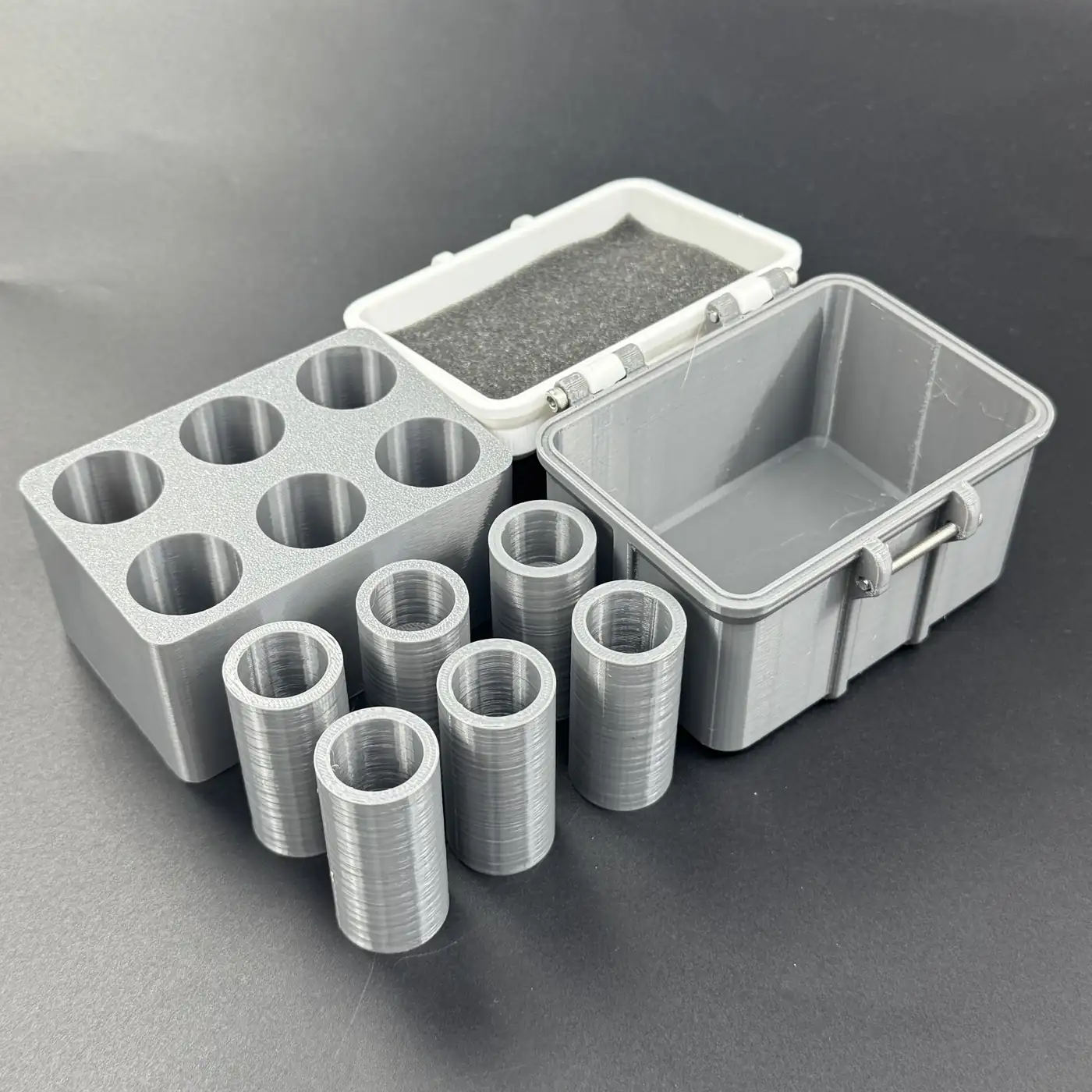 exploded view of multi-size vial storage box: foam-lined lid, six-bore insert, six cavities and base shell
