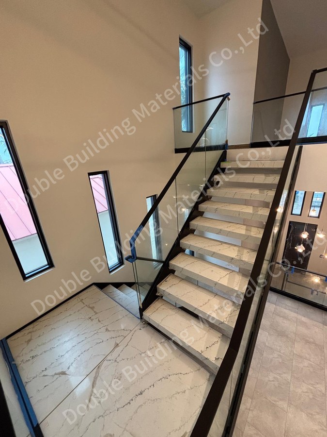 Texas pale stone treads in dark side panels with glass balustrade