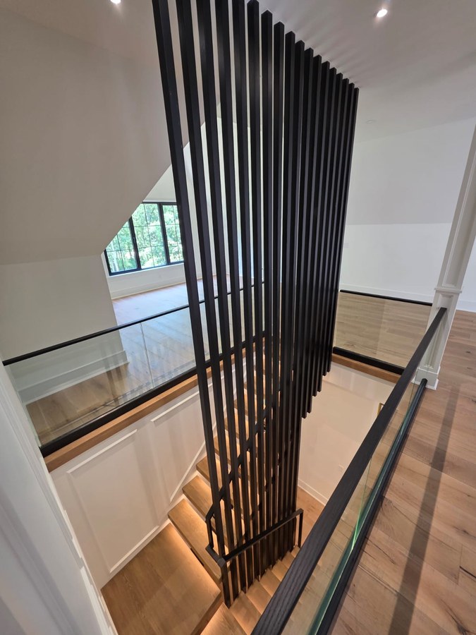 Floor to ceiling vertical black square tube screen at Charleston stairwell