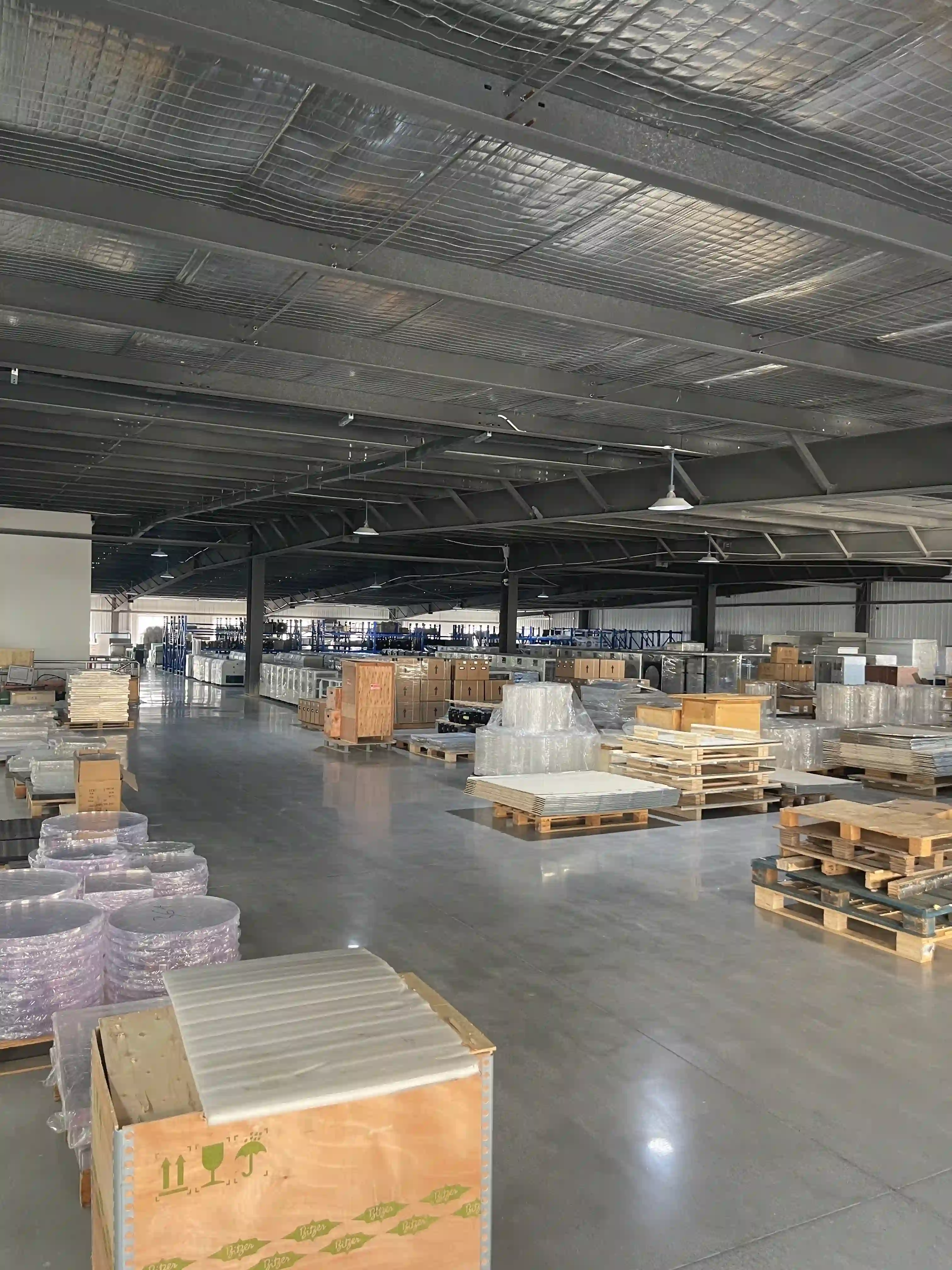 The spacious third floor of the Geliss factory utilized as a standardized warehouse, filled with neatly organized wooden crates and wrapped freeze-drying equipment ready for global shipping.